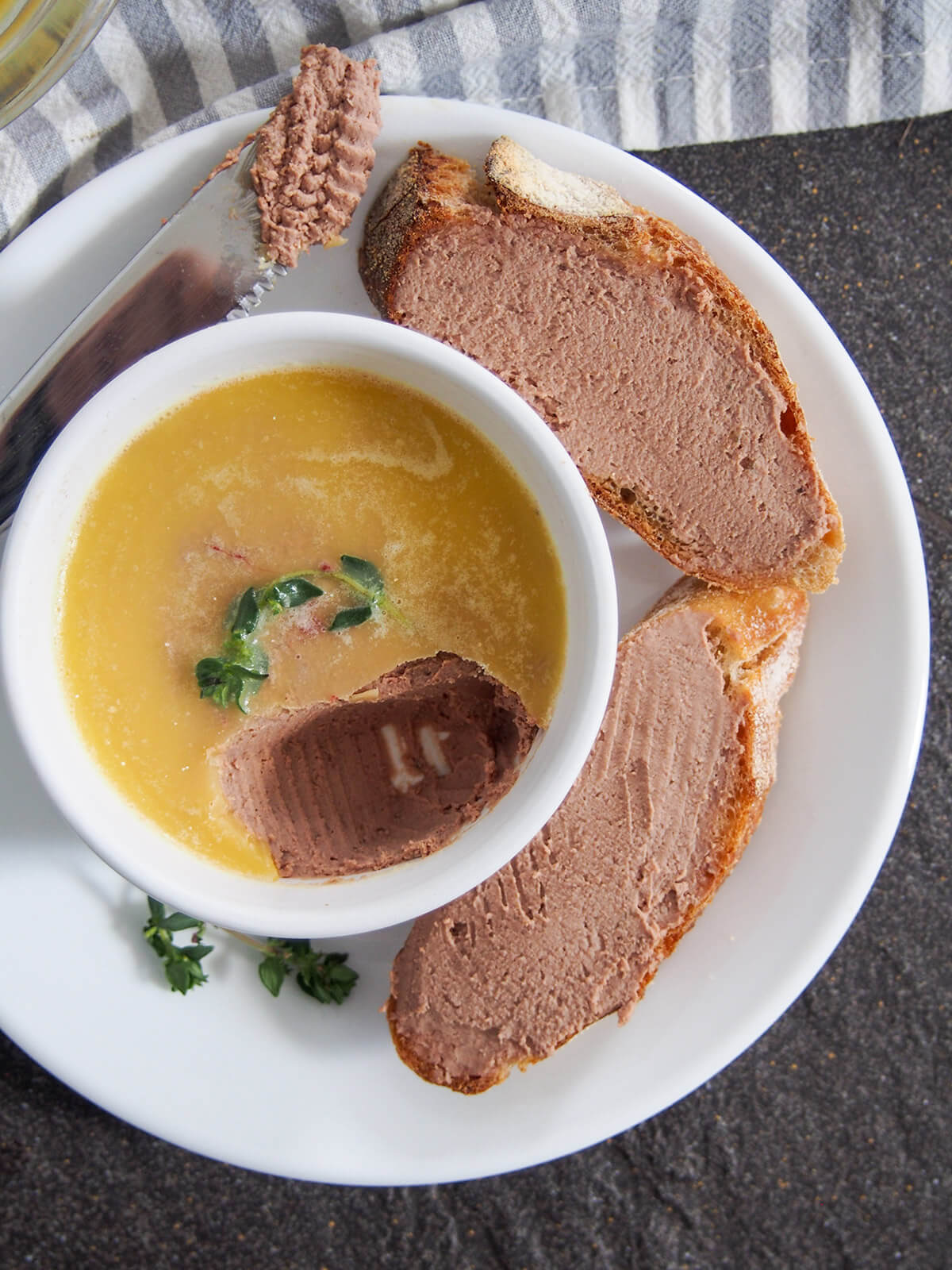 chicken liver pate in dish with some spread on bread to side and a little on knife to other side of dish