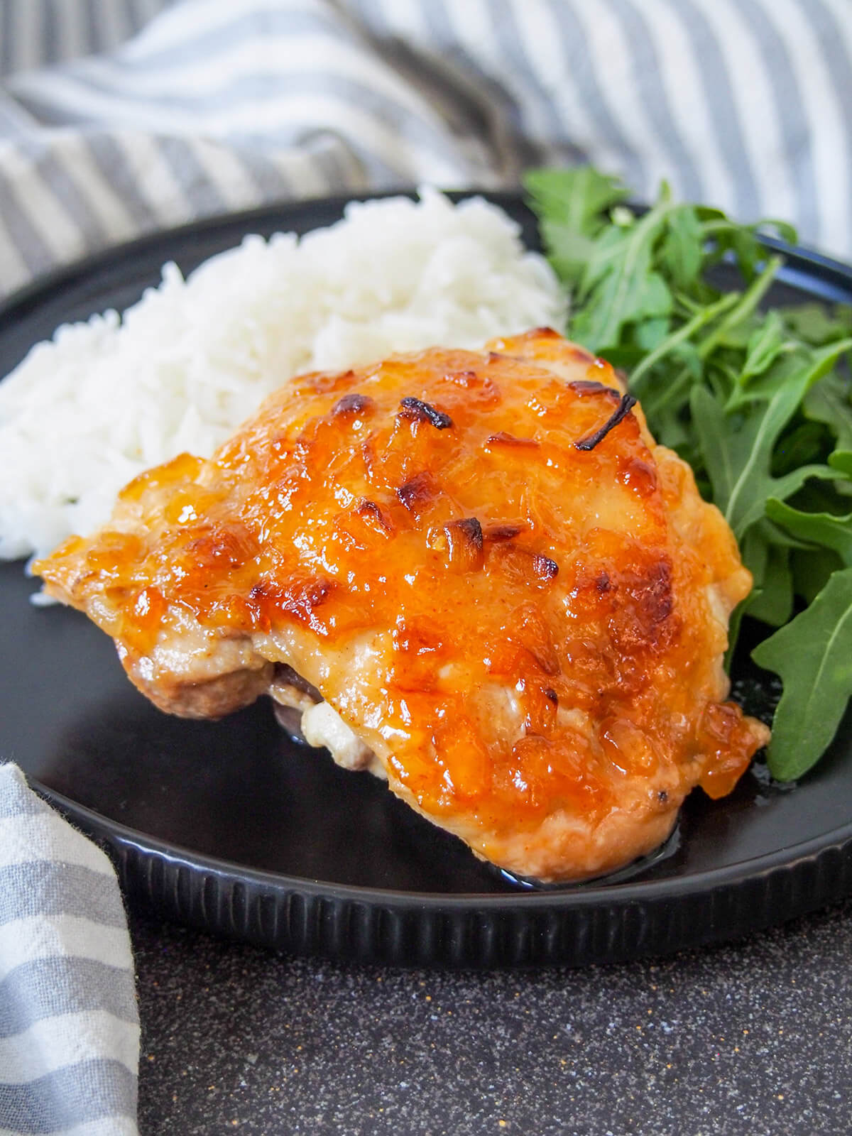 chutney chicken on plate with rice behind