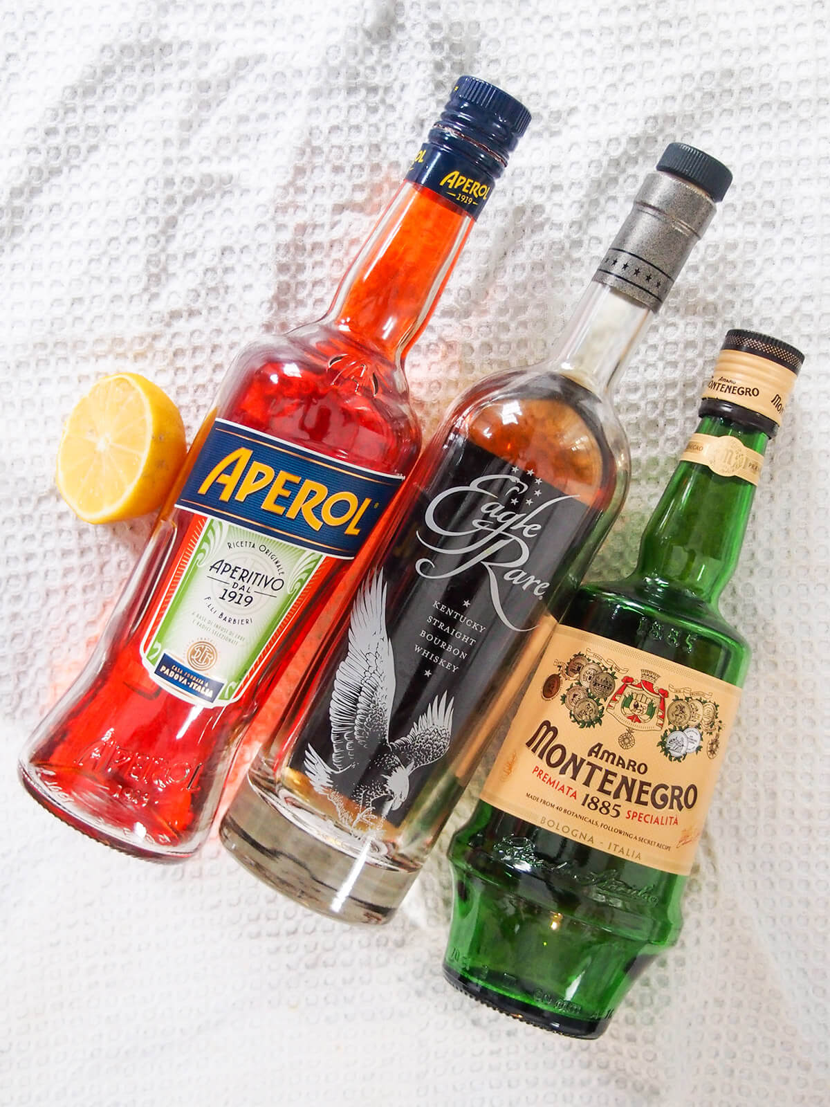 ingredients for cocktail - bottles and lemon laid next to each other