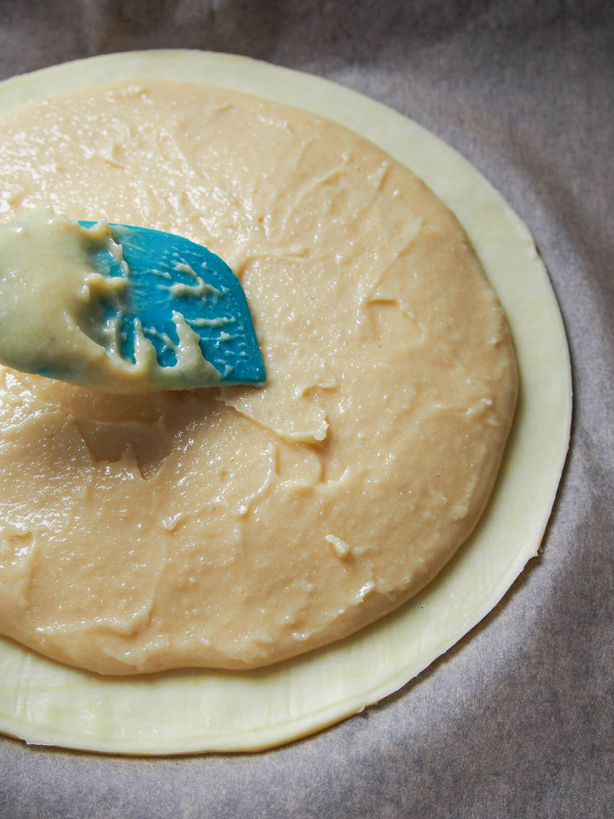 adding filling on top of round of pastry