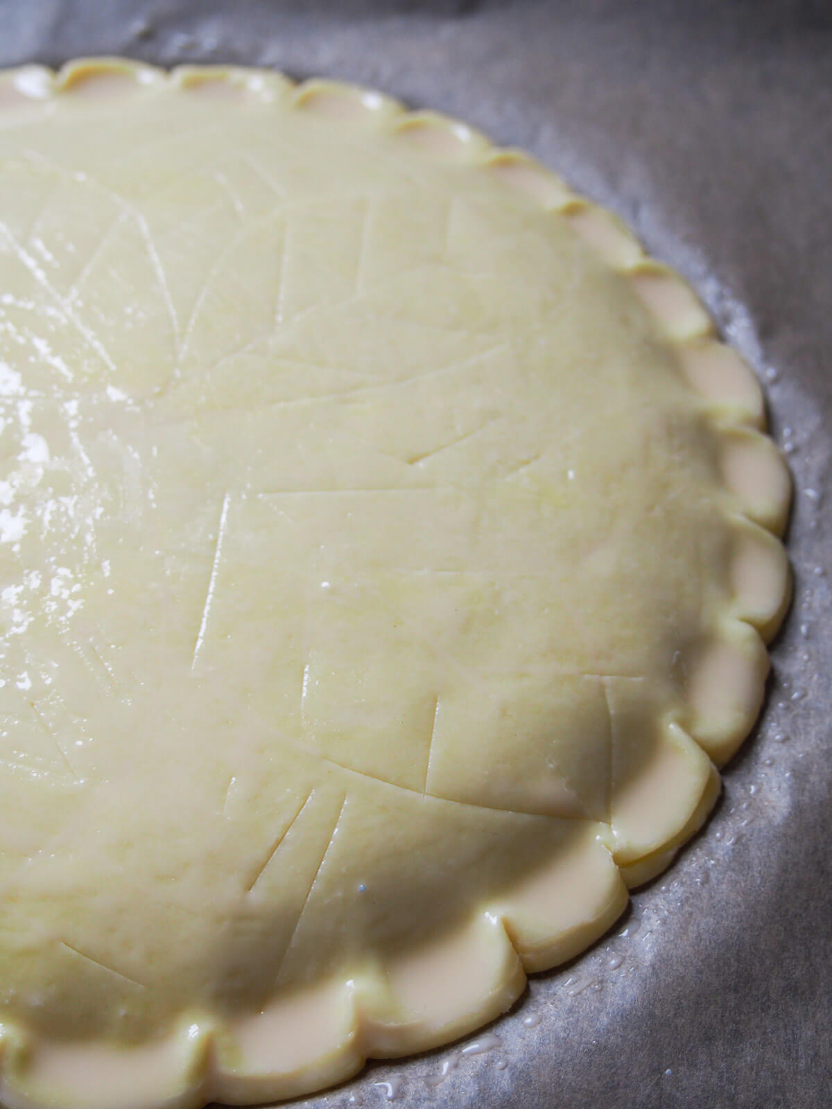 tart with scored decoration on top and eggwash