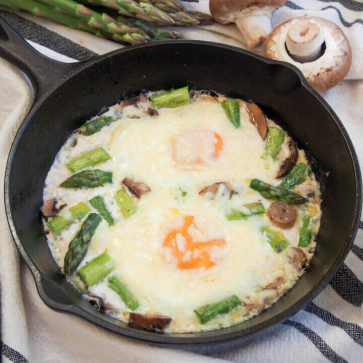 baked eggs with mushroom and asparagus in skillet