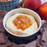 dish with baked goat cheese with peach chutney and chips to side