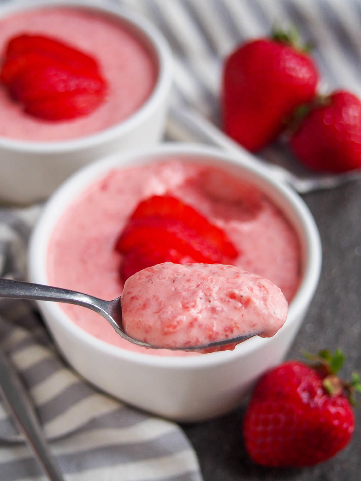 spoonful of easy strawberry mousse held in front of dish