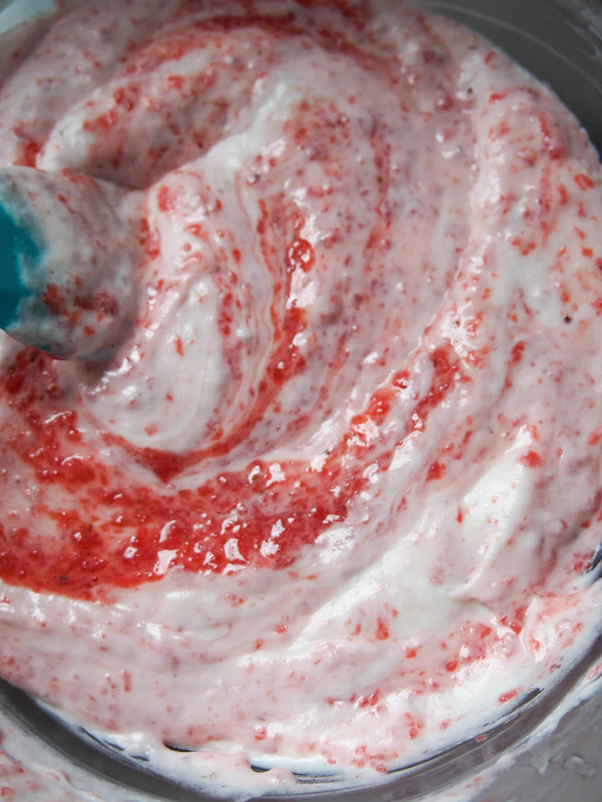 folding together cream and strawberries