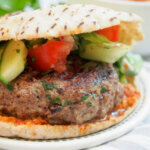 lamb kofte burger topped with salad in pita bread