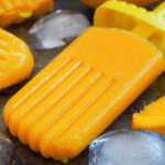 mango paletas with ice cube to side