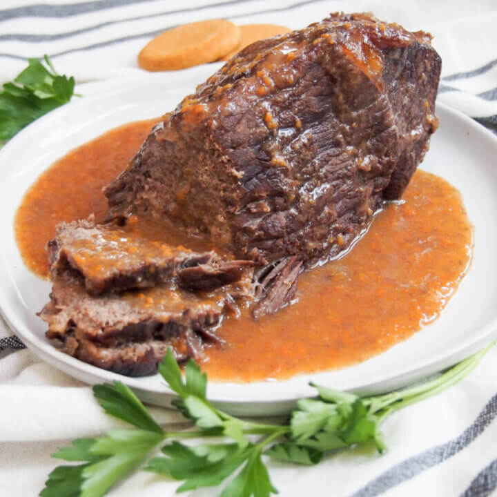sauerbraten on serving platter with some sliced to front