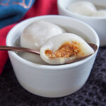 peanut filling showing on Chinese sweet dumplings - tangyuan - resting on bowl