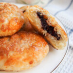 plate of eccles cakes with one split open showing filling