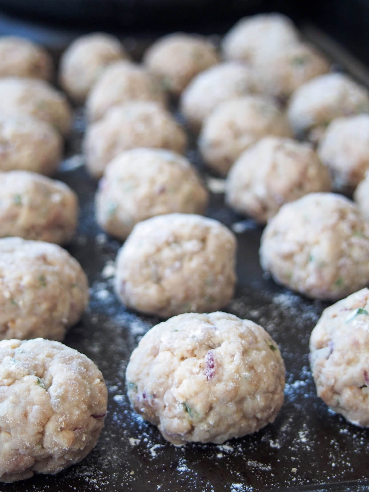 formed floured meatballs on baking sheet