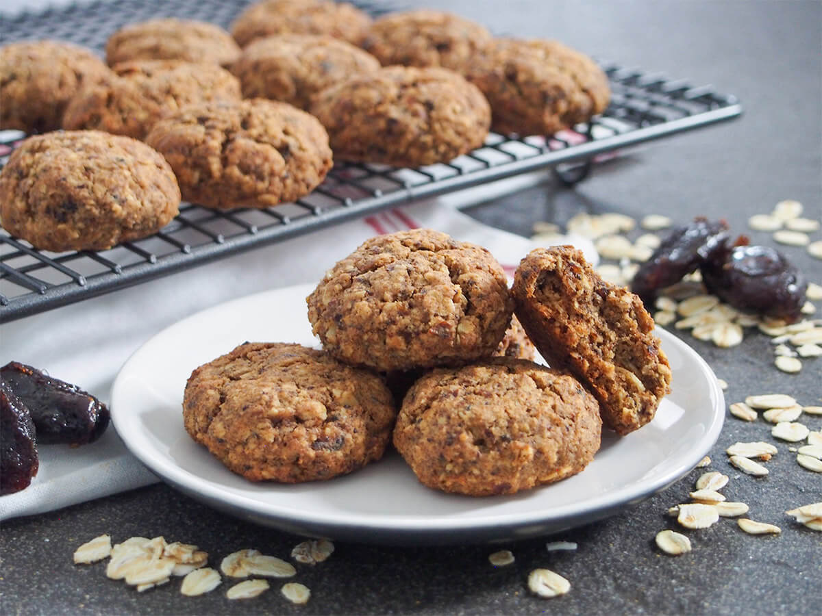 plate of oatmeal date cookies with more on rack behind