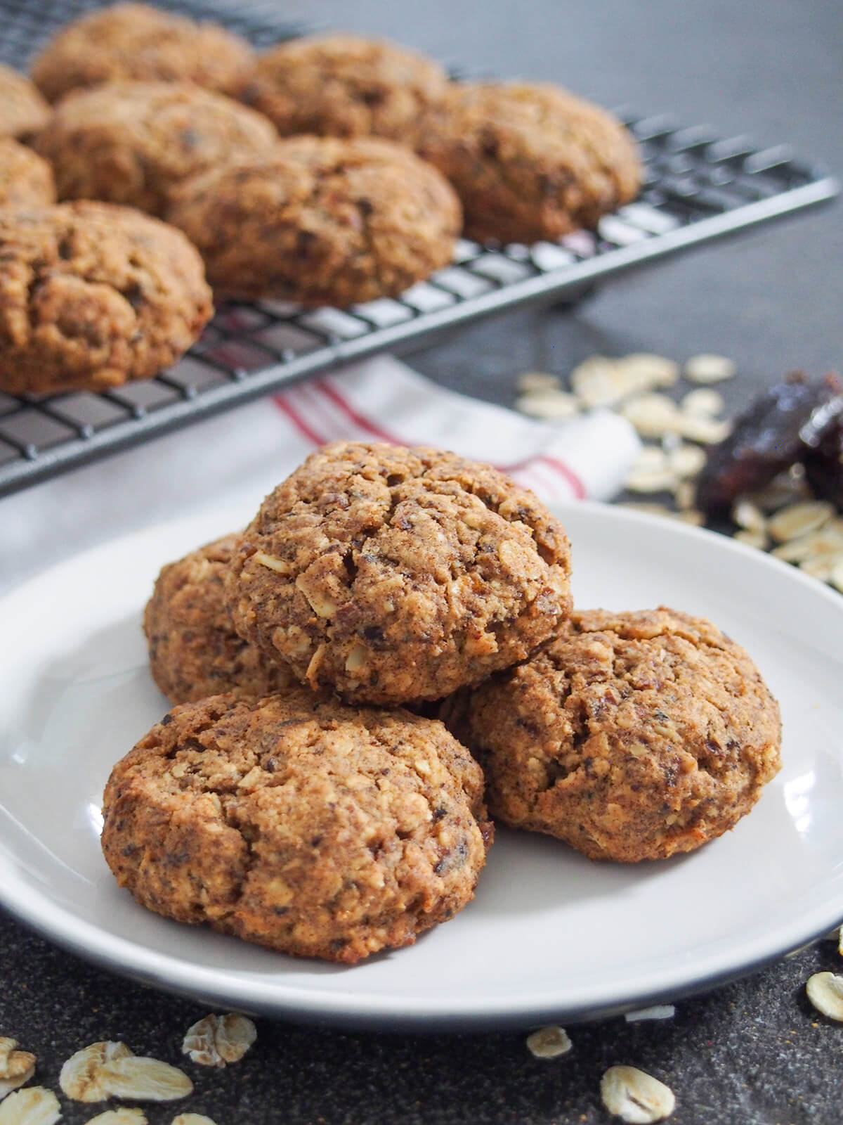 plate of oatmeal date cookies and rack behind with more