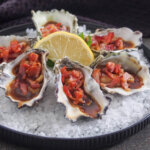 plate of oysters Kilpatrick on a bed of rock salt