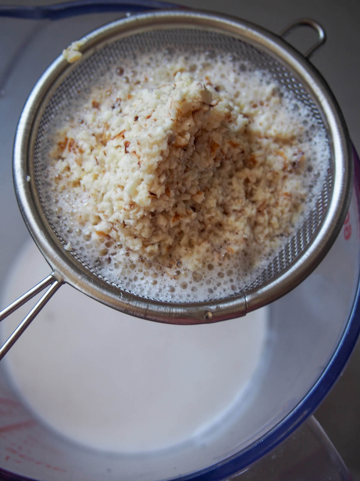 straining blended tiger nuts to make horchata de chufa straining tiger nuts to give milk