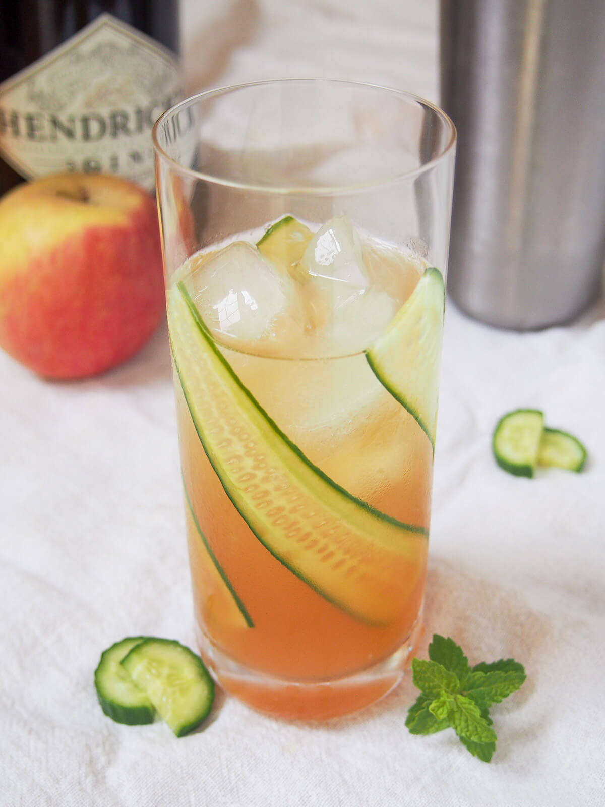 glass of English garden cocktail with cucumber pieces to side