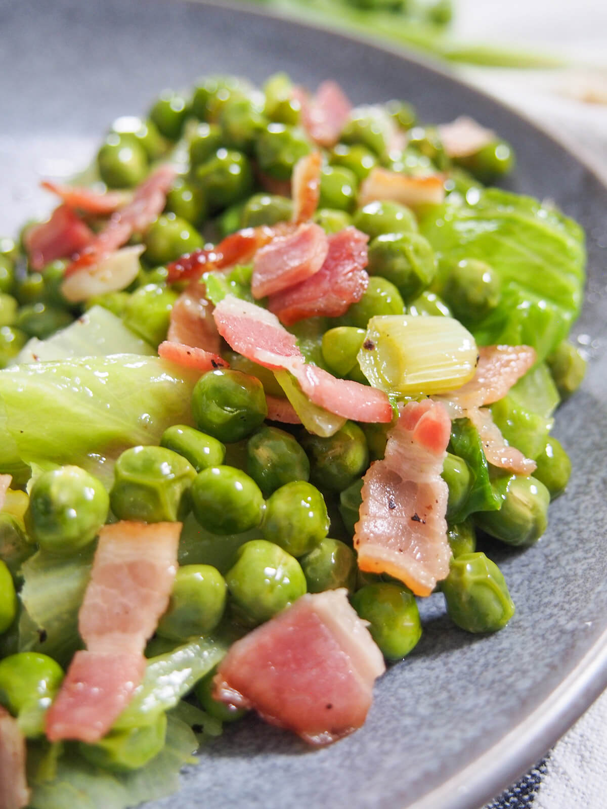 close up of peas with bacon and lettuce mixed through