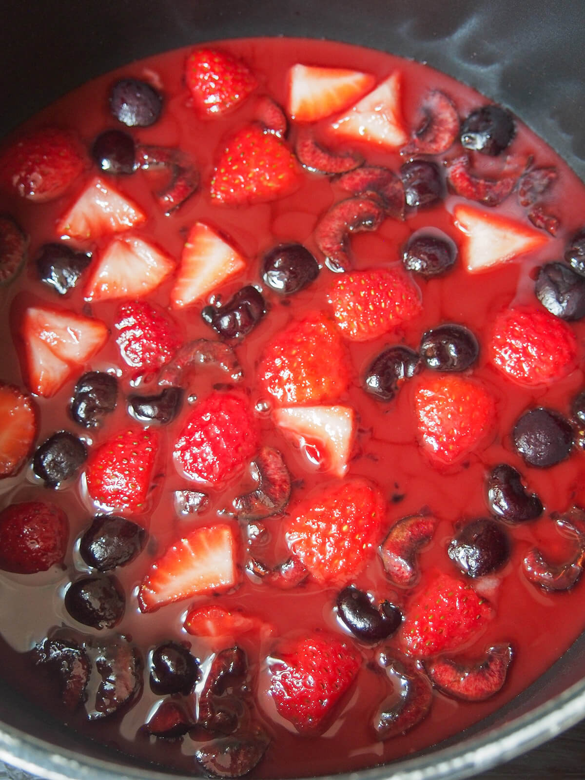 adding cherries and strawberries to sauce base