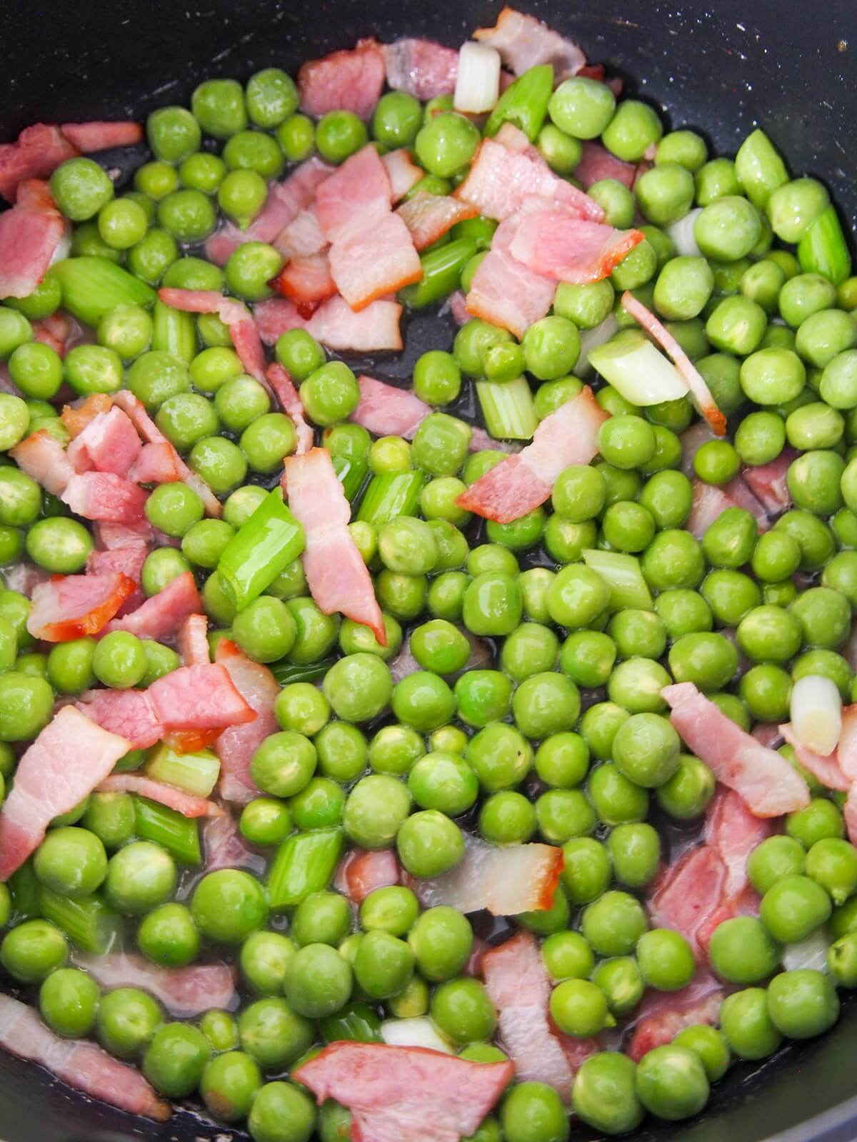 peas added to bacon and onion in pan