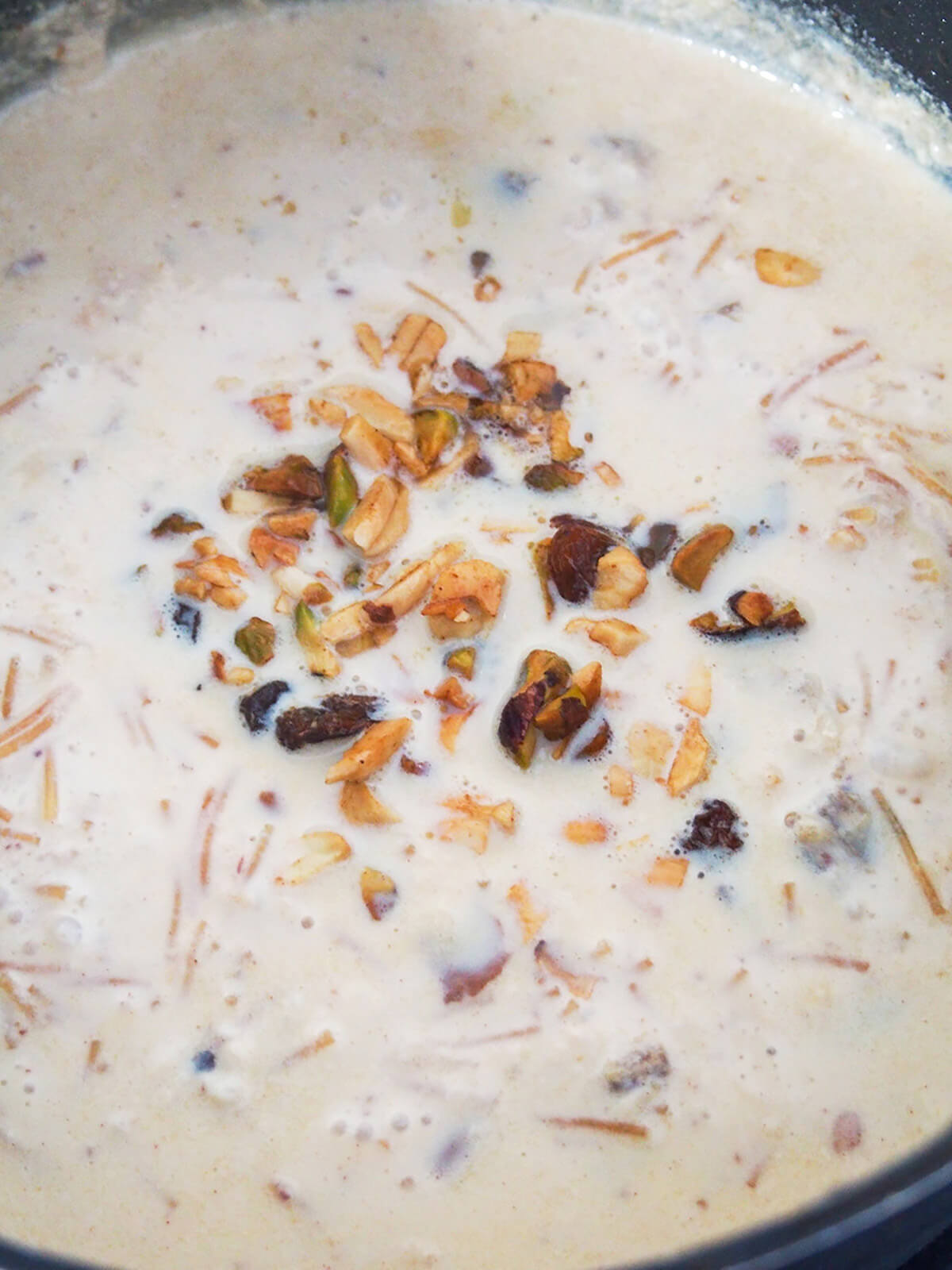 adding nuts into milk and noodle mixture