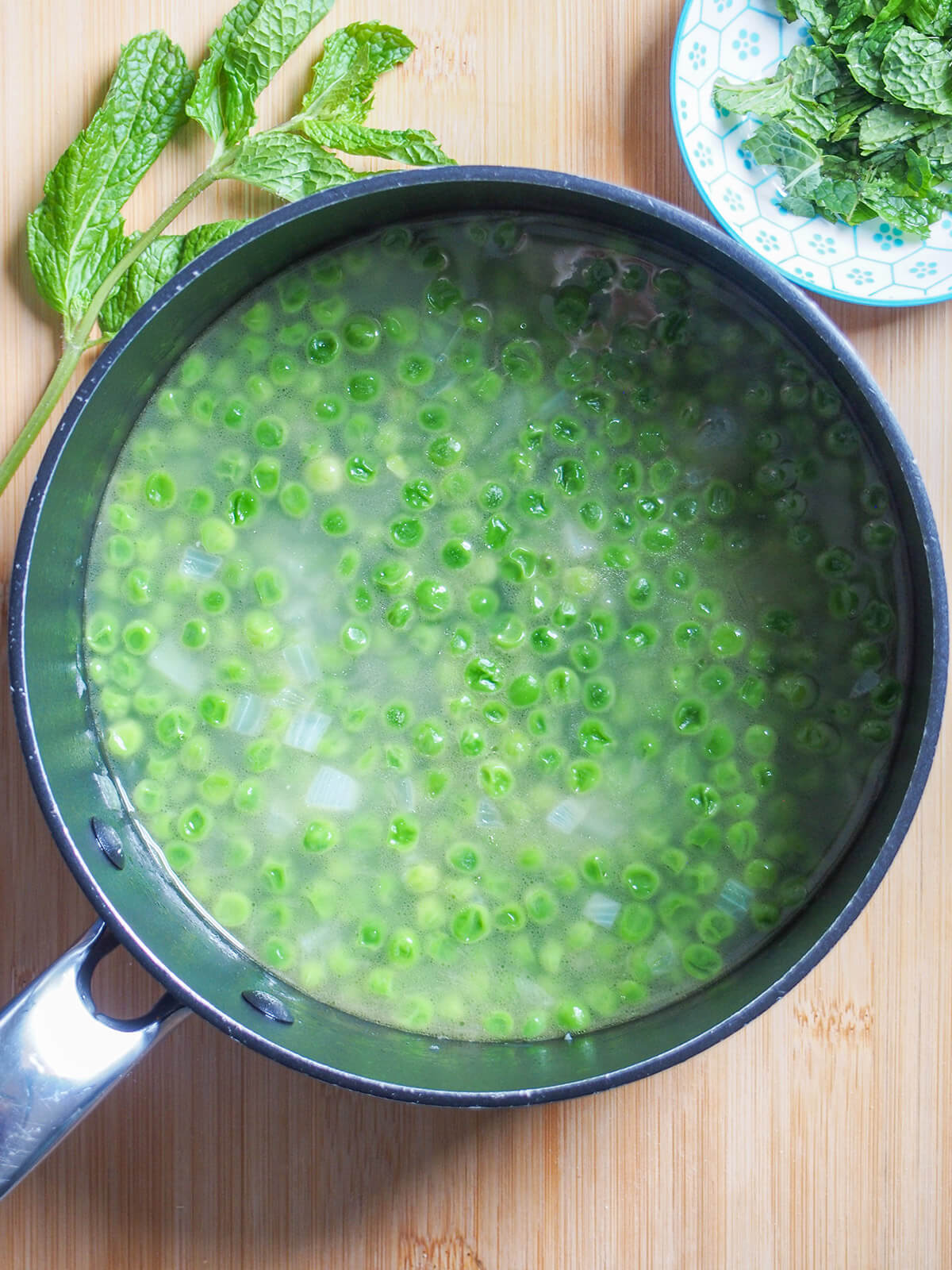 cooked peas and onion in stock with mint to side