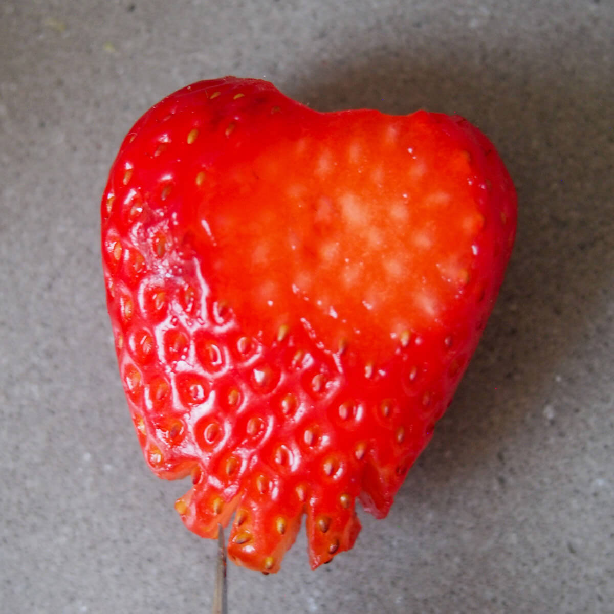 cutting slits into bottom of strawberry to make chick 'tail'