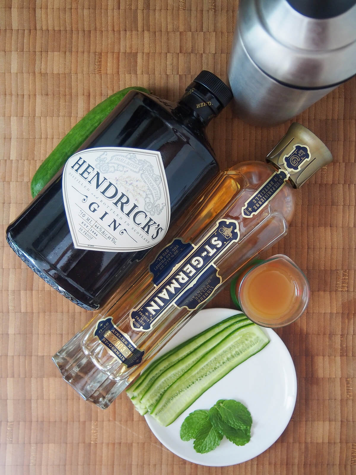 bottles of gin, elderflower liqueur, cucumber slices, mint leaves