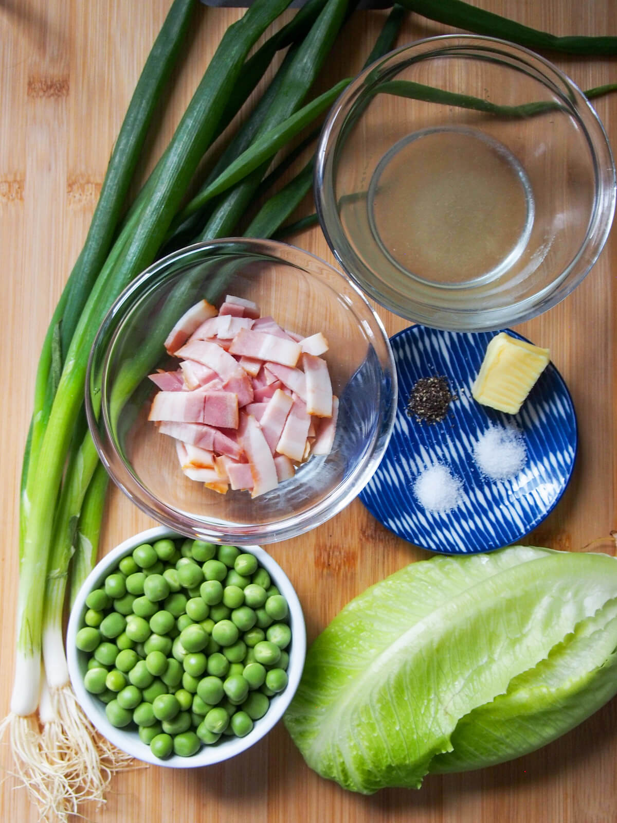 bowls of bacon, peas, stock with onions and lettuce to side