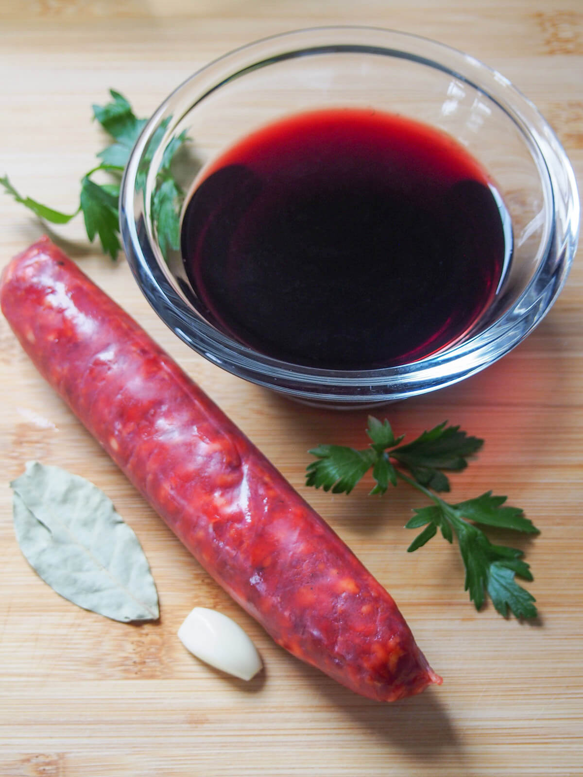 chorizo, wine, parsley, bay and garlic on cutting board