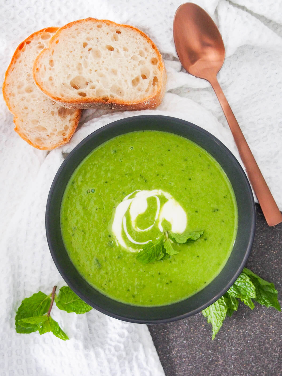 bowl of soup, slices of bread and spoon from overhead