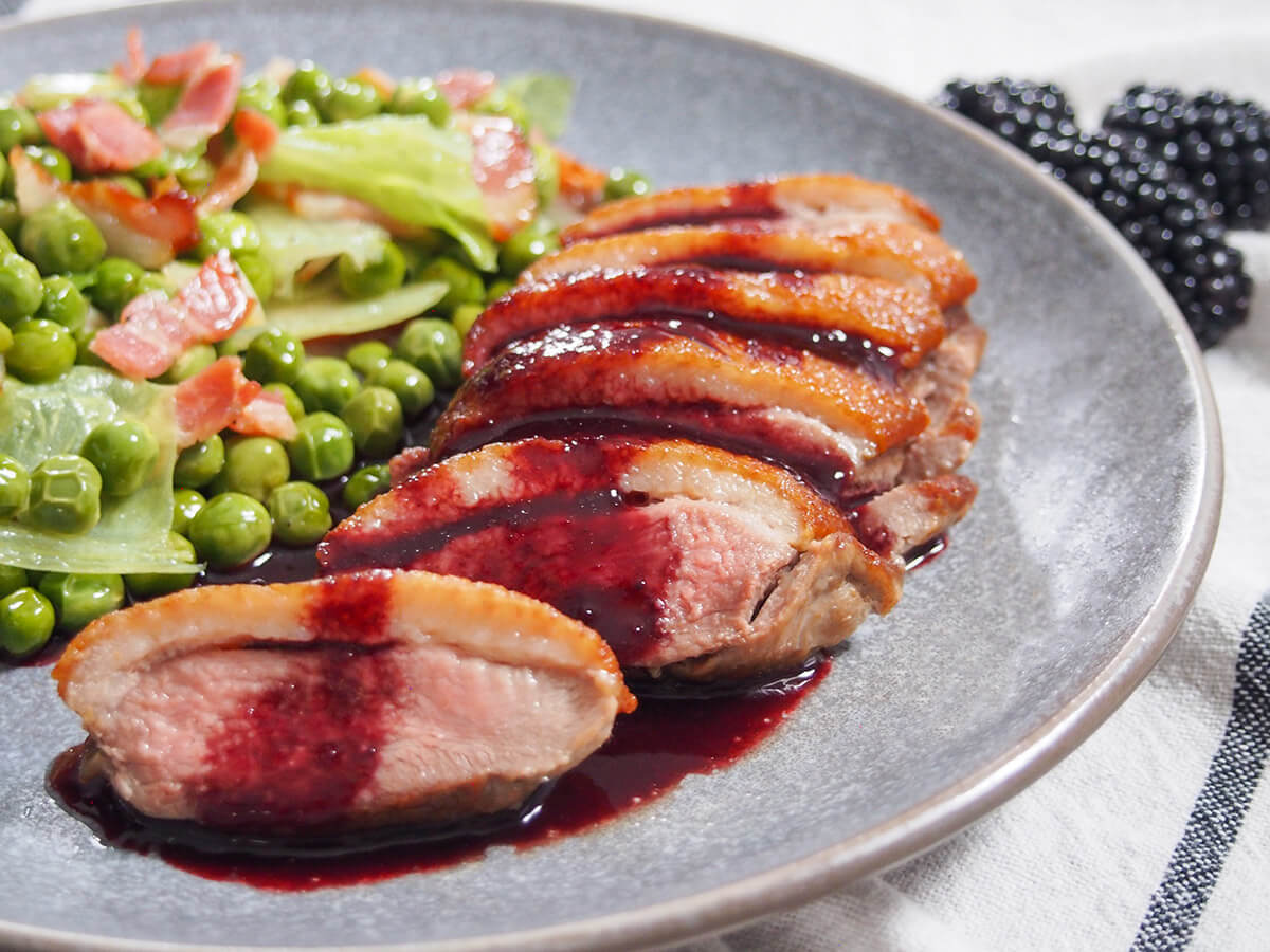 pan seared duck breast with blackberry sauce with French peas to side