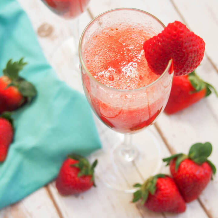 strawberry bellini in glass topped with strawberry