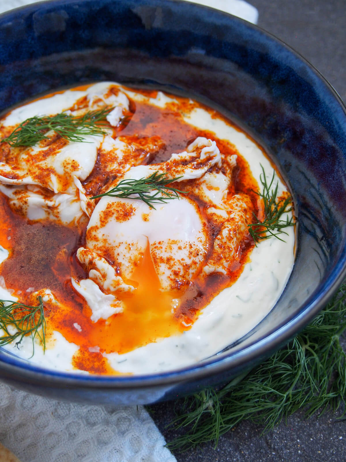 side view of Turkish eggs cilbir with yolk running into sauce