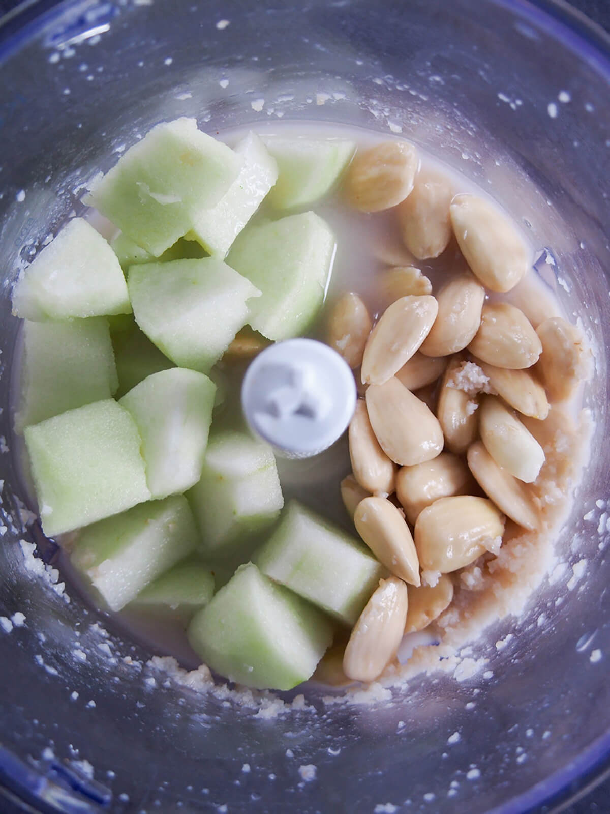 adding apple and almonds to blender