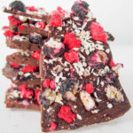 piece of blueberry raspberry chocolate bark with stack behind
