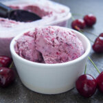 bowl of cherry ice cream with cherries around bowl
