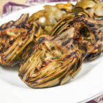 plate of grilled artichokes showing grill marks on artichokes