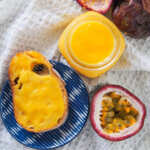 jar of passion fruit curd with bread with curd to side and passion fruit below