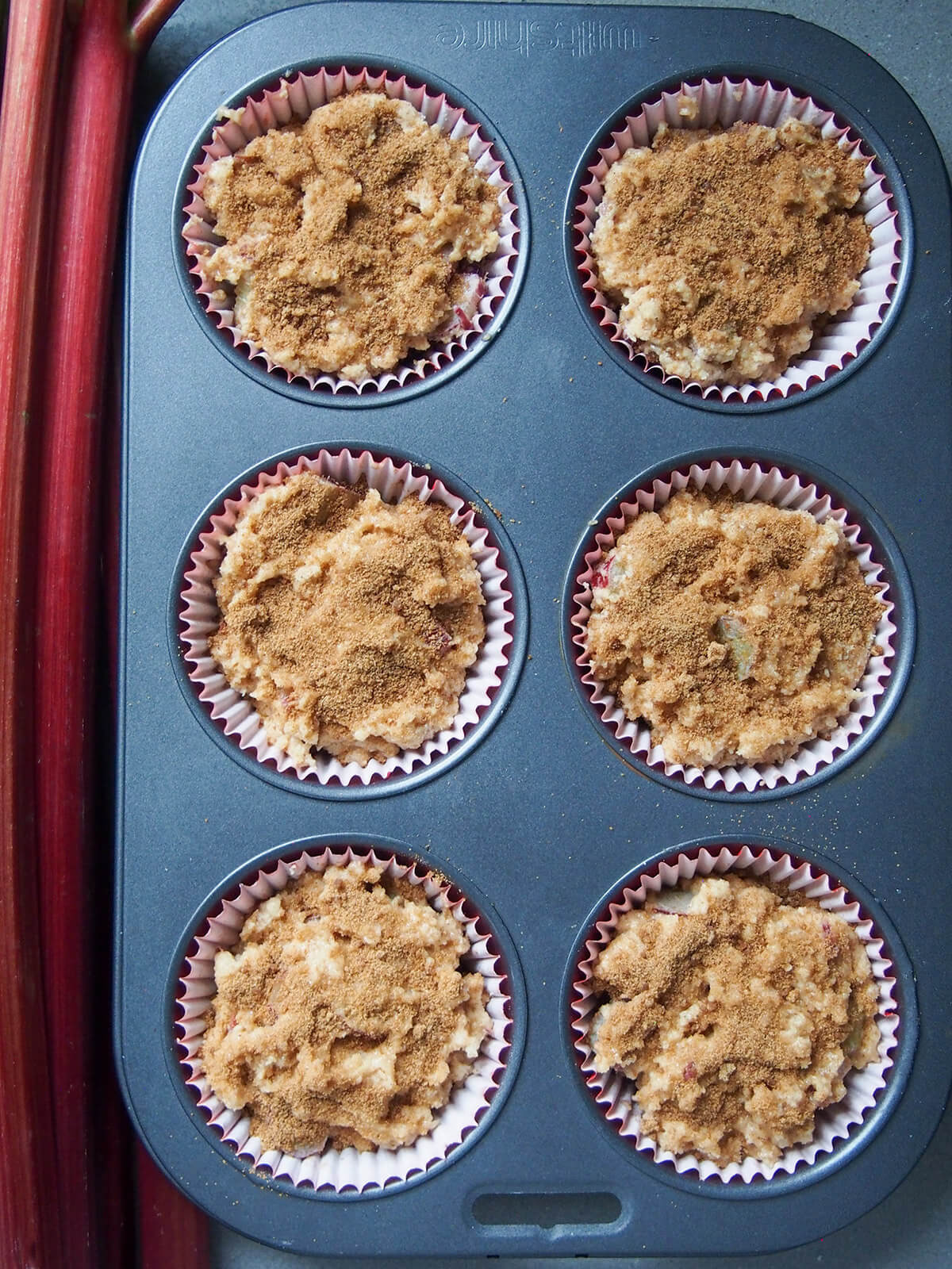 muffins topped with cinnamon sugar ready to bake