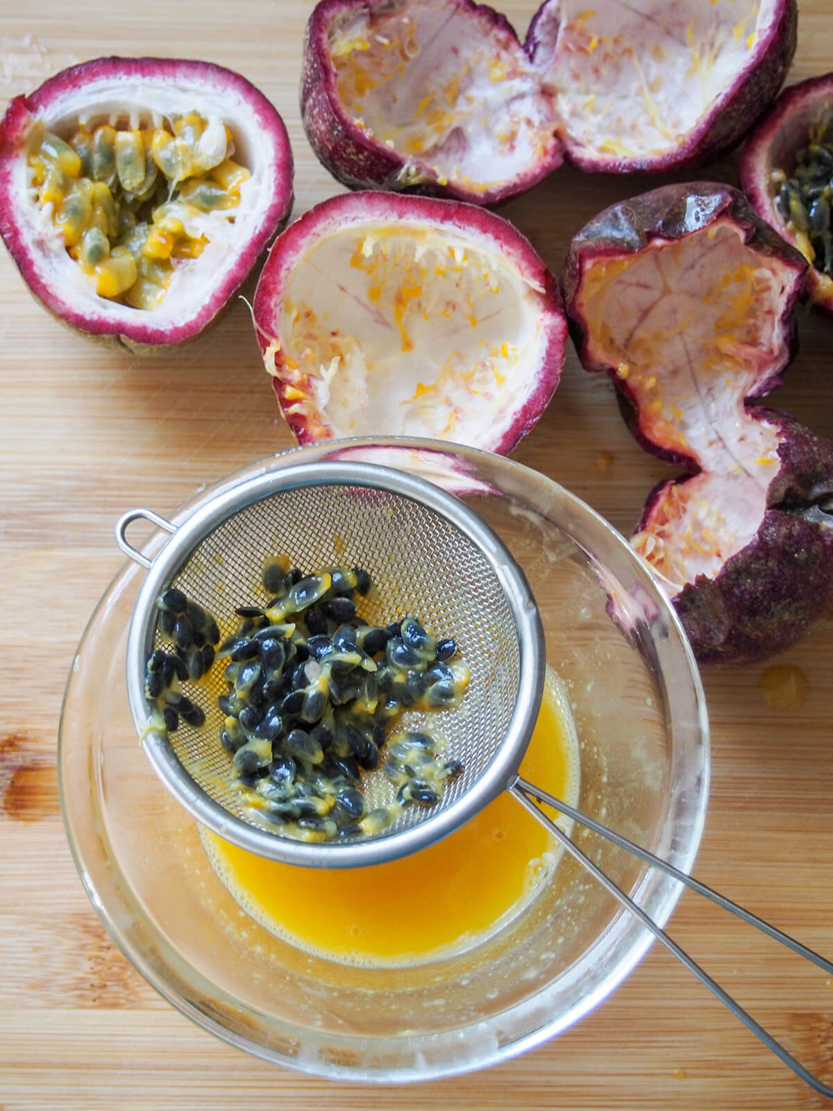 straining juice and pulp from passion fruit