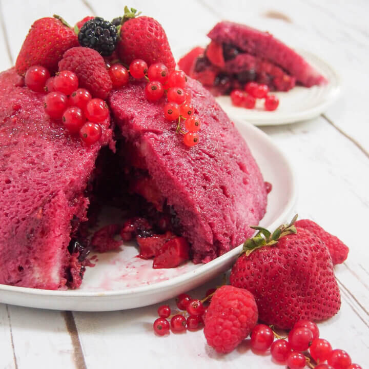 summer pudding with slice cut out and fruit on top