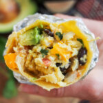 vegetarian breakfast burrito held in hand