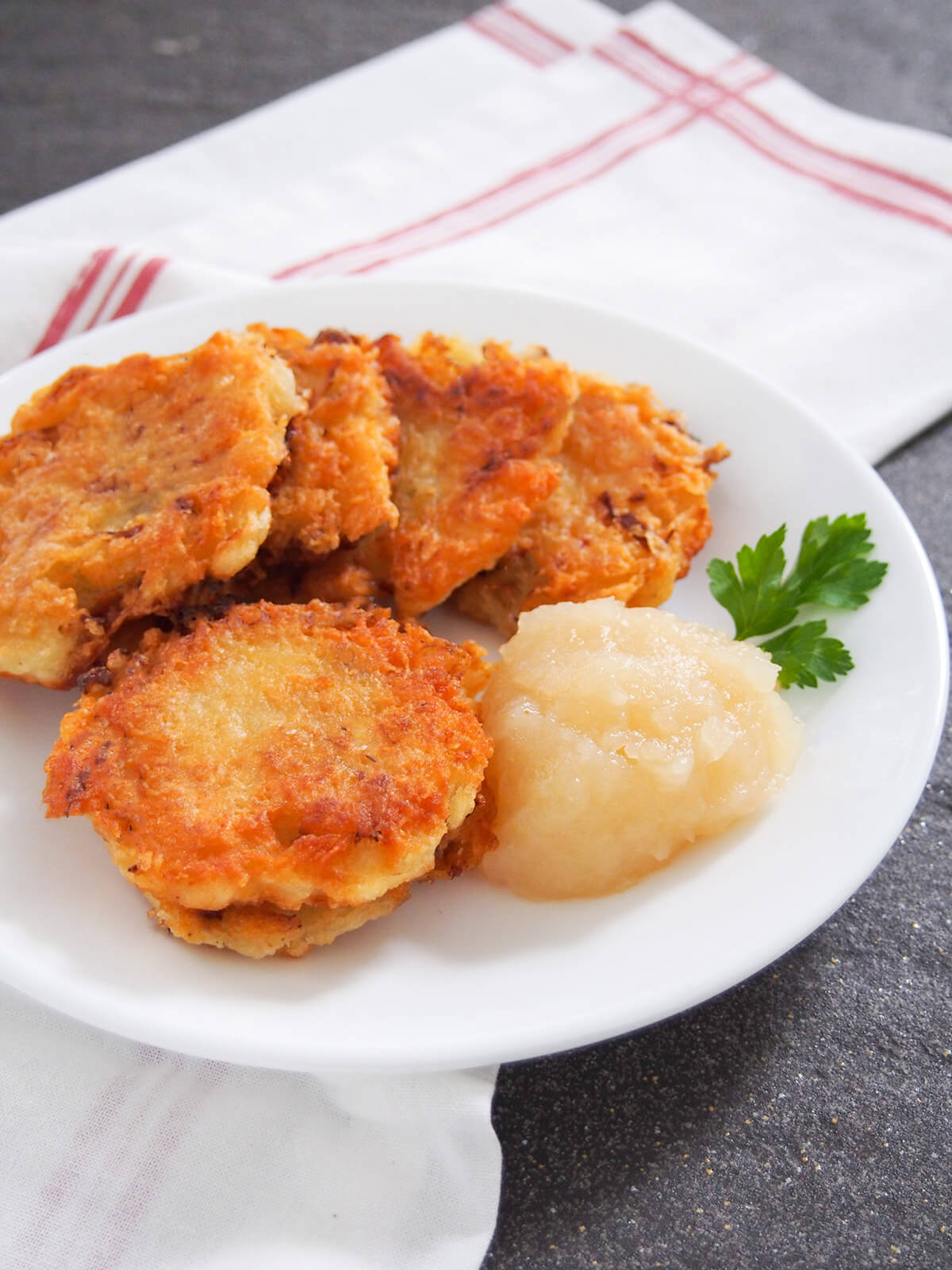 German potato pancakes with apple sauce to side and parsley garnish