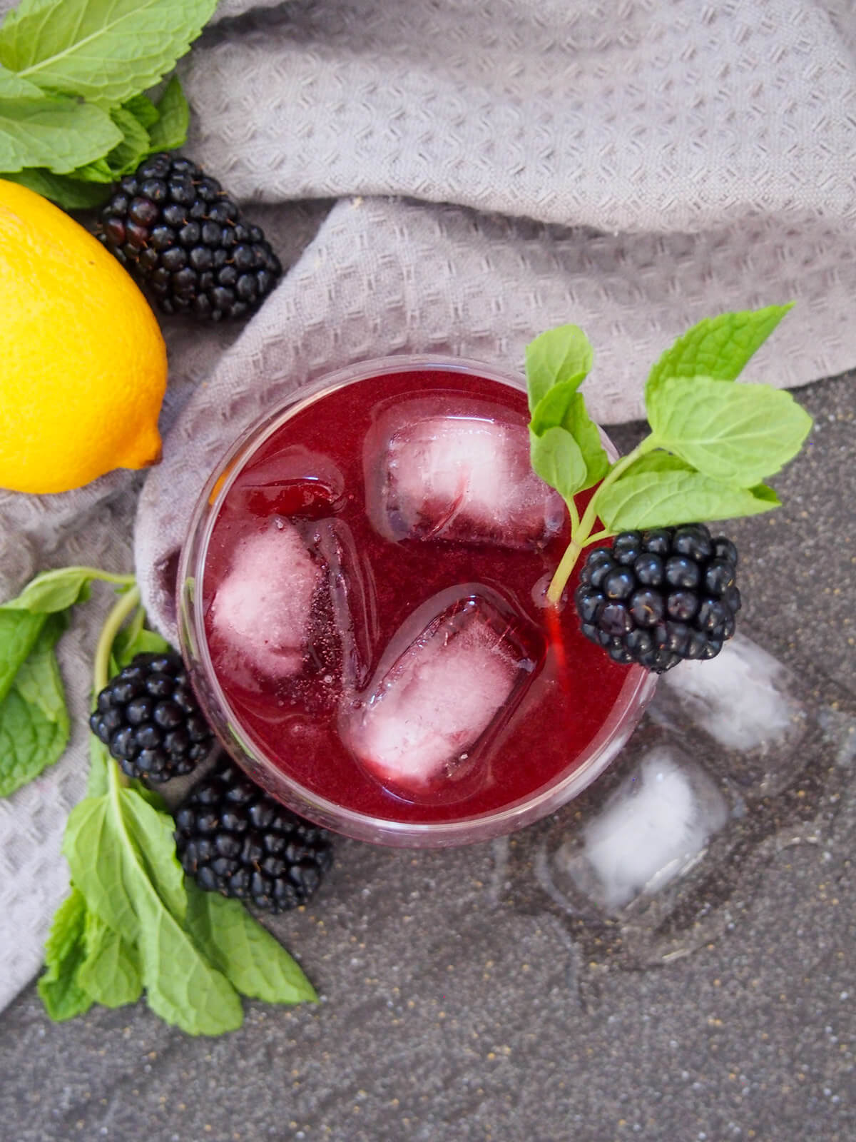 overhead view of glass of blackberry bourbon smash