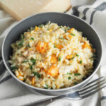 bowl of Butternut squash risotto with chicken and arugula with fork in front