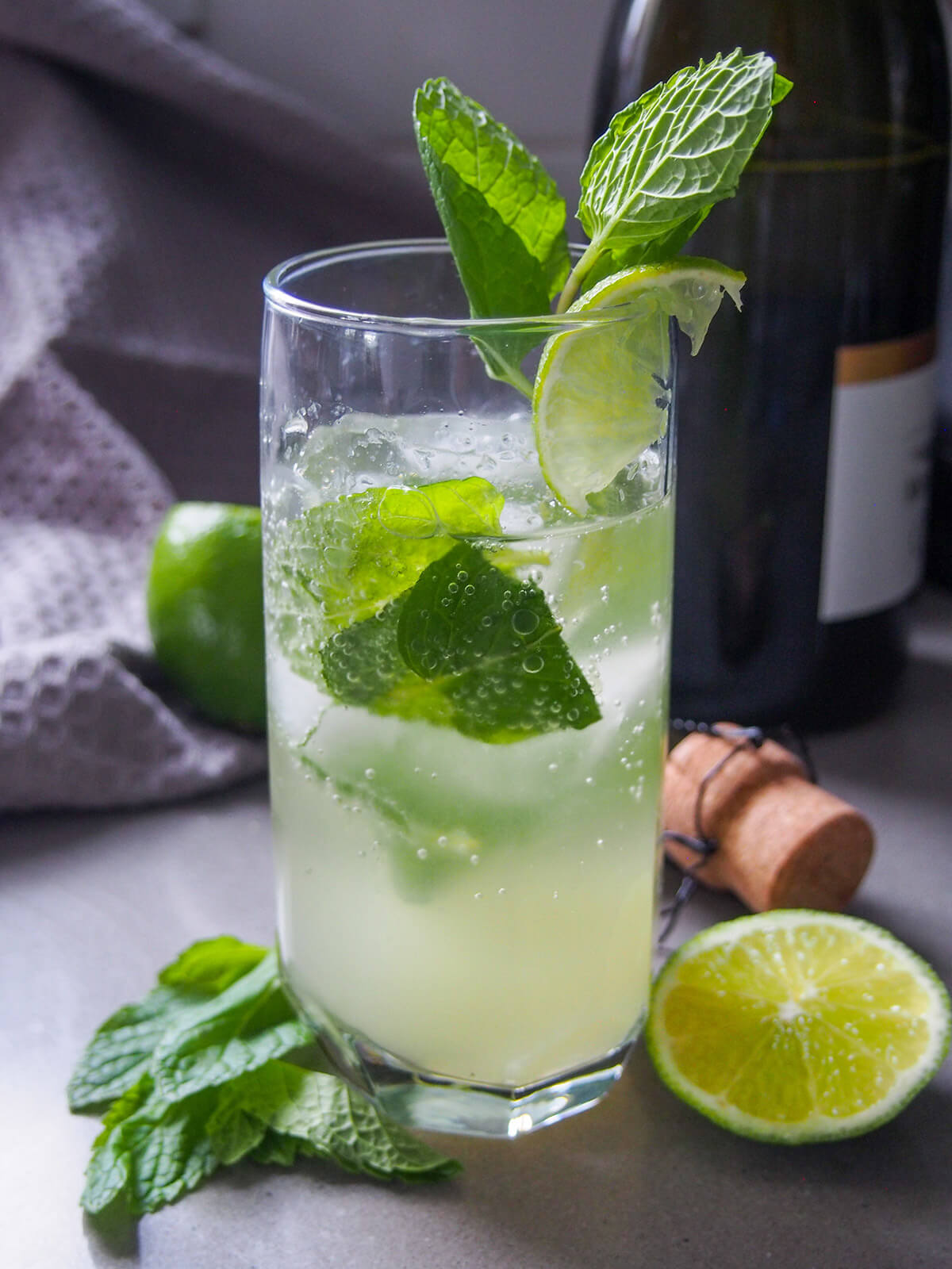 glass of champagne mojito showing bubbles and mint leaves in glass