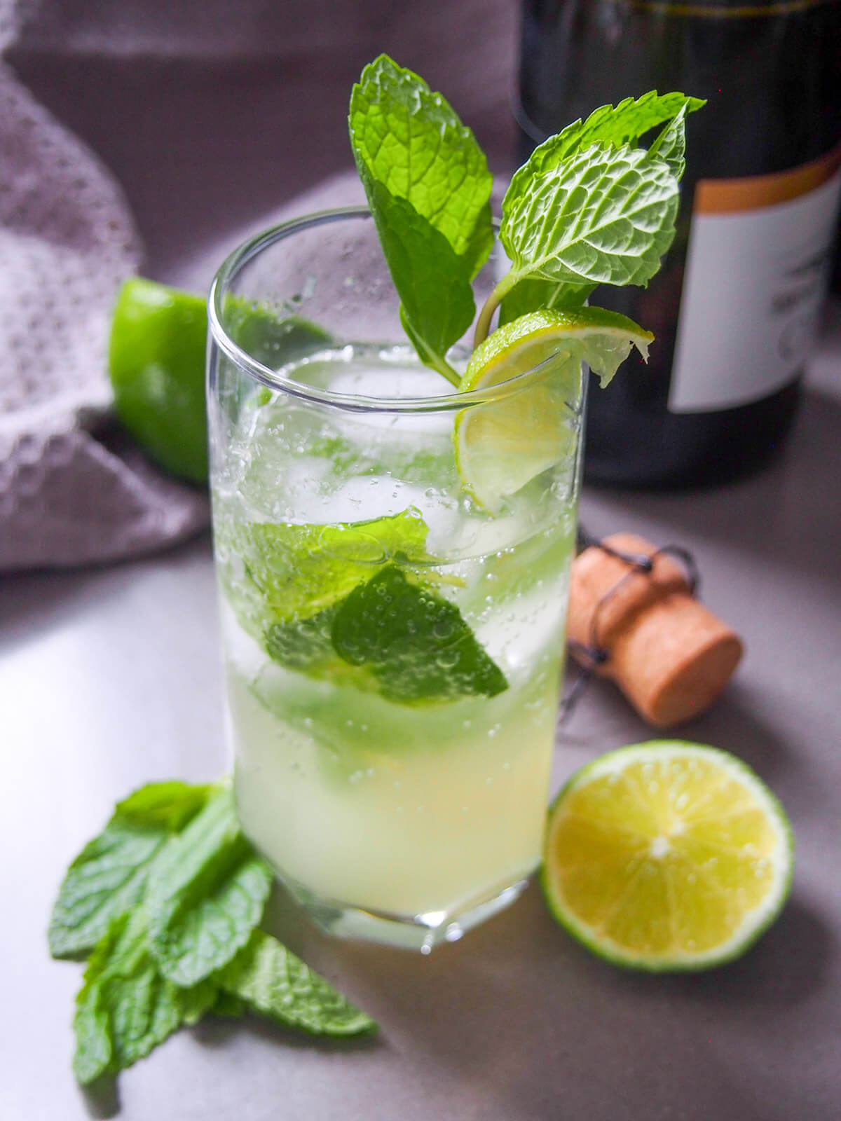 champagne mojito glass with bottle behind