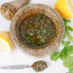 pestle and mortar with chermoula sauce and spoon with sauce to bottom