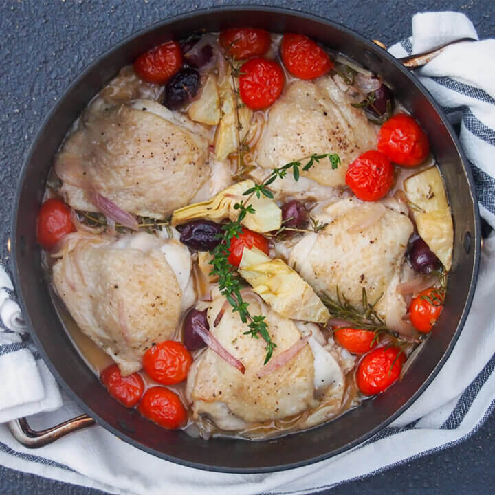 dish of chicken provencal with tomatoes and artichokes to top
