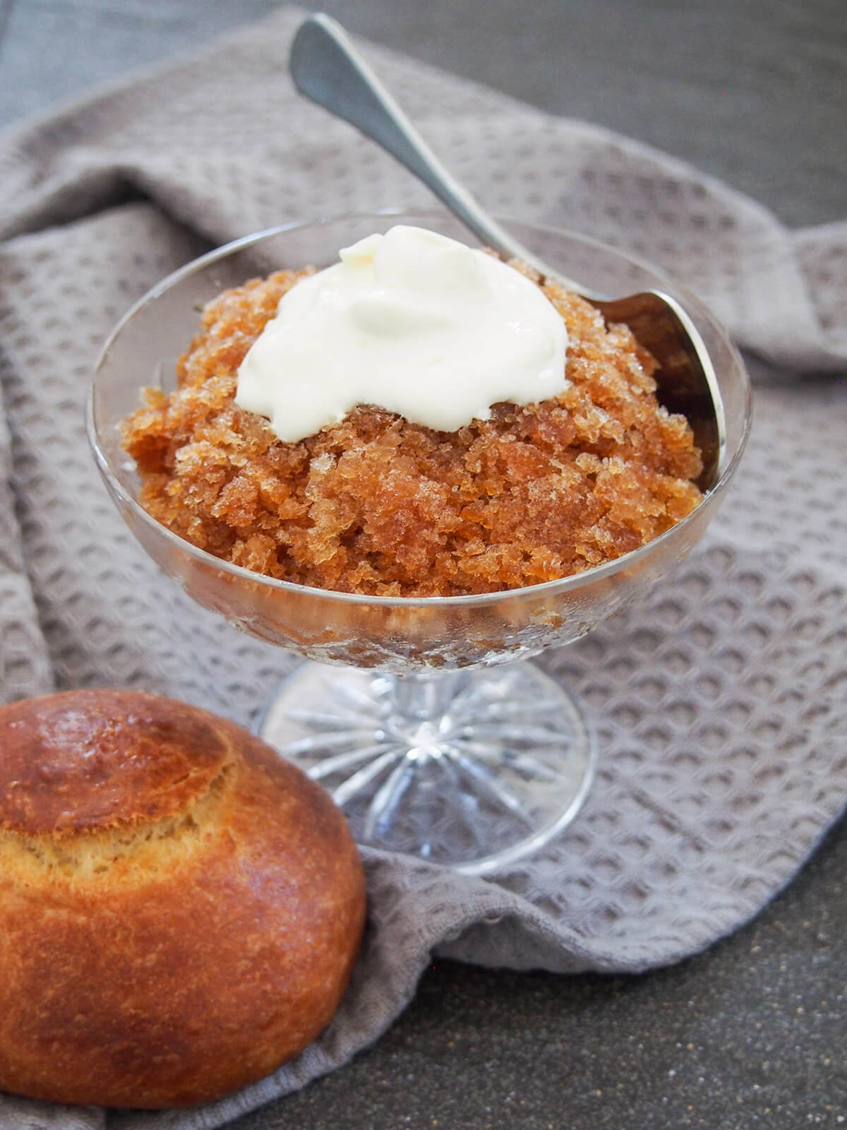 coffee granita topped with cream with spoon in glass